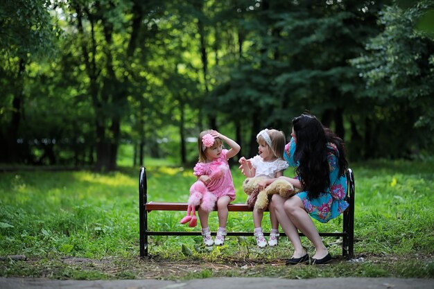 Mãe com duas filhas gêmeas para passear no parque