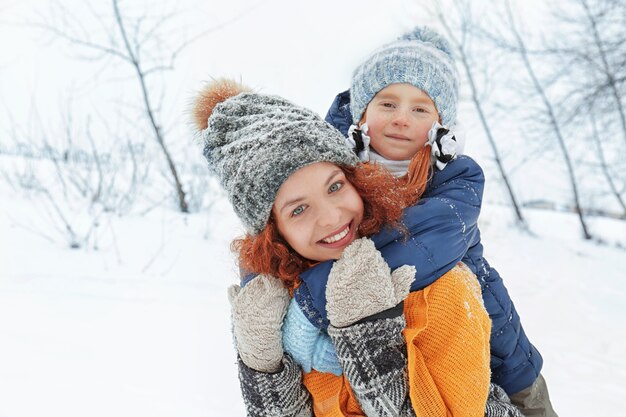 Mãe com filha brincando no parque de inverno