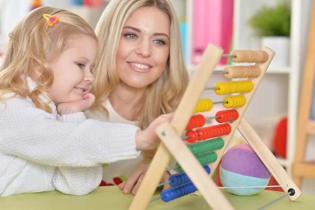 Mãe com filha contando com balcão