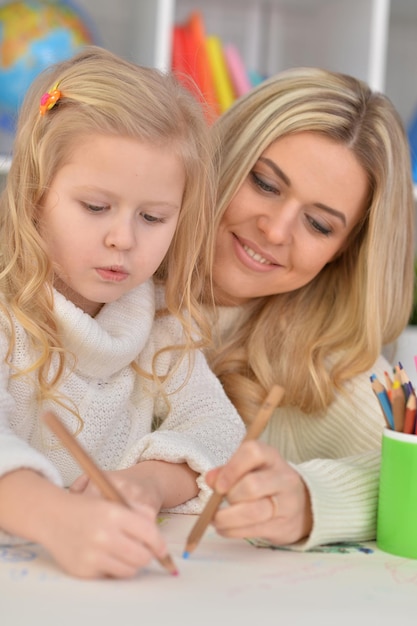 Mãe com filha desenhando com lápis coloridos