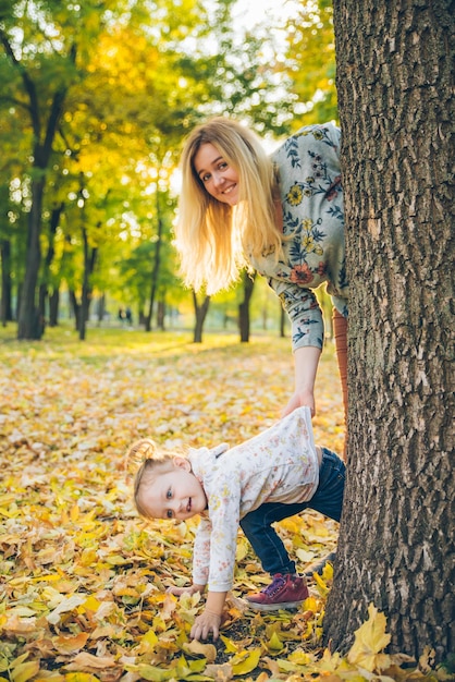 Mãe com filha espreita da árvore