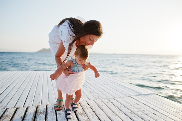 Mãe com filha menina no resort turquia no cais contra o mar mediterrâneo.