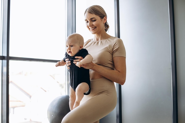 Mãe com filha pequena se exercitando no tapete de ioga