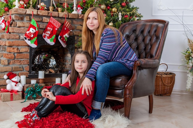 Mãe com filha perto da árvore de Natal