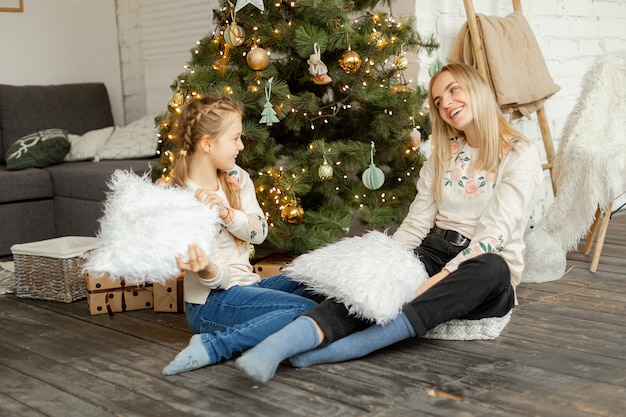 Mãe com filha perto da árvore de natal