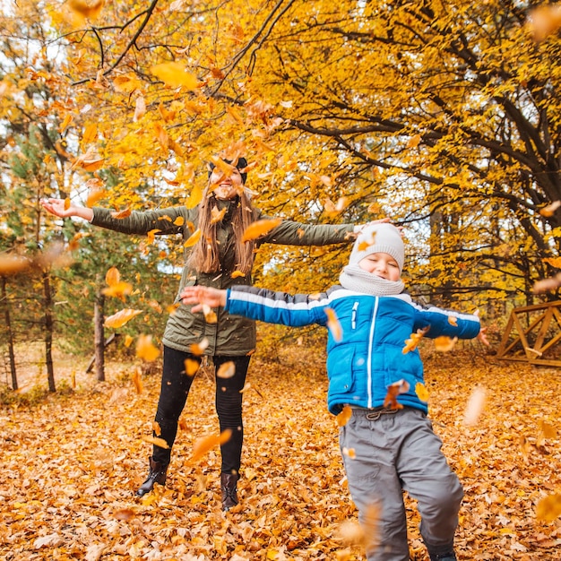 Foto mãe com filho brincando ao ar livre no parque da cidade de outono