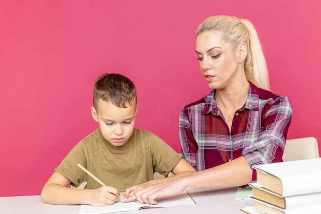 Mãe com filho em casa fazendo lição de casa juntos em tempo de quarentena.