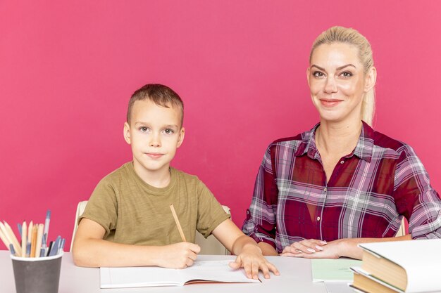 Mãe com filho em casa fazendo lição de casa juntos em tempo de quarentena.