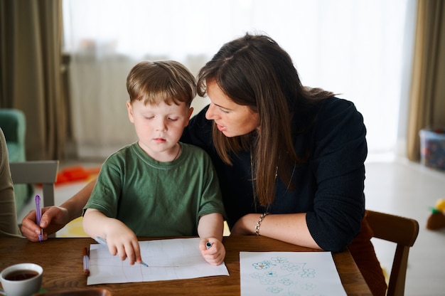 Mãe com filho pequeno pintando e desenhando juntos