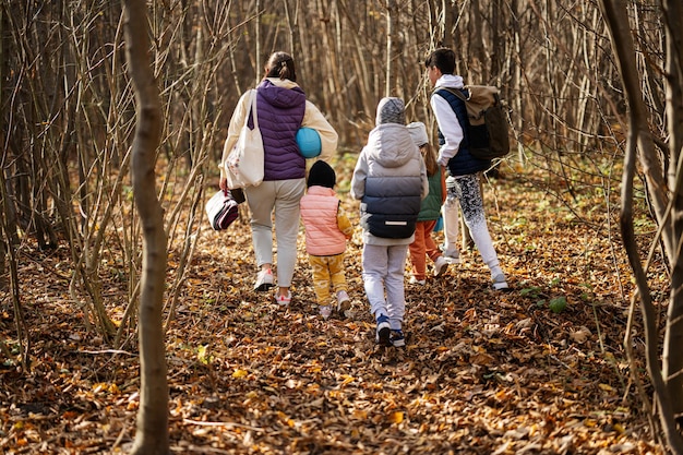 Mãe com filhos em lazer familiar na atividade de outono na floresta