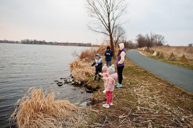 Mãe com filhos na margem do lago