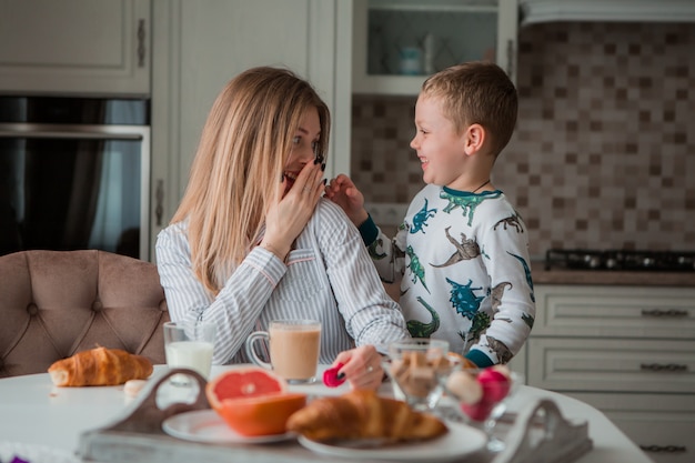 mãe com filhos tomando café na cozinha