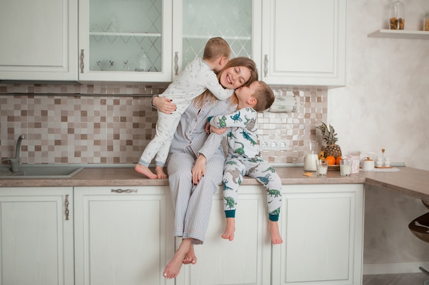 mãe com filhos tomando café na cozinha