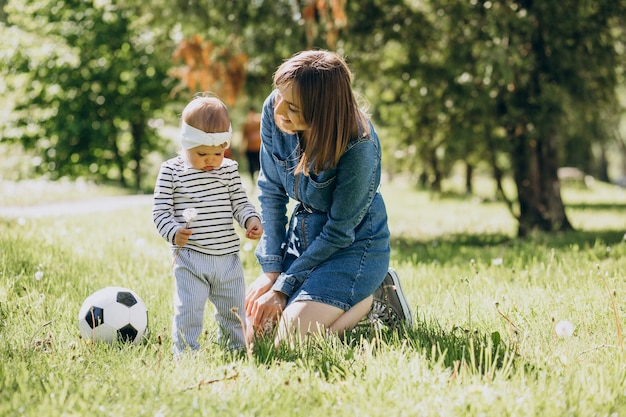 Mãe com menina brincando com bola no parque