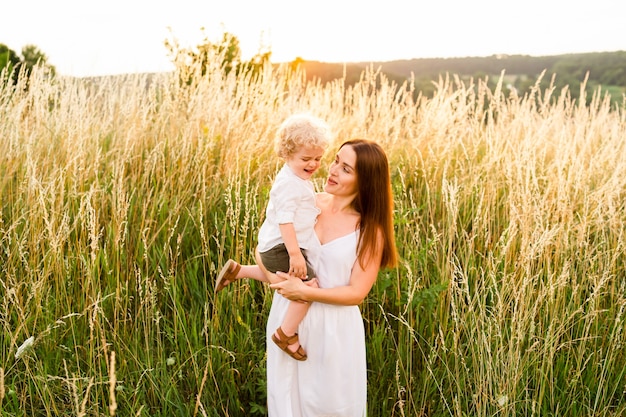 Mãe com o filho nos braços na natureza