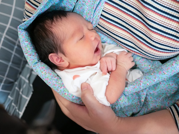 Mãe com seu bebezinho asiático dormindo no carrinho de bebê