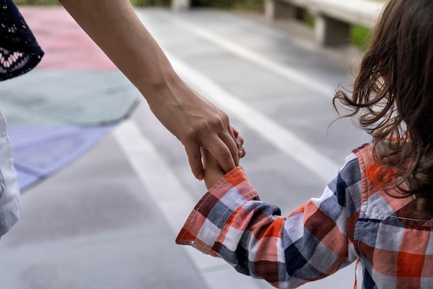 Foto mãe com seu filho latino-americano nas costas de mãos dadas caminham juntos pessoas irreconhecíveis conceito e ensino do dia das mães