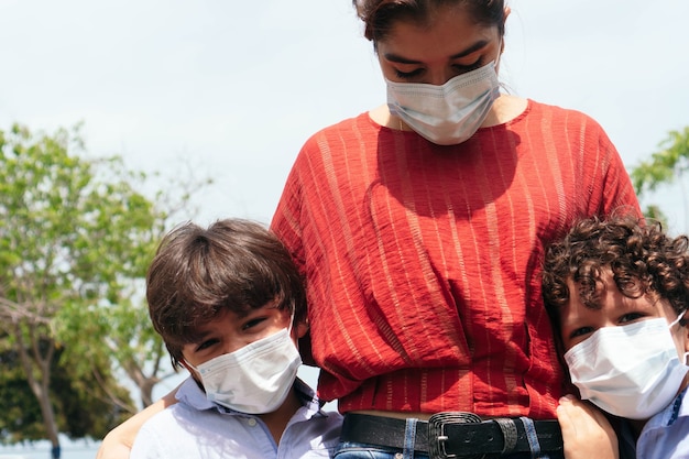 Mãe com seus filhos usando chiclete protetor ao ar livre