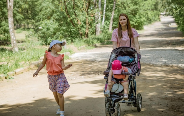 mãe com suas filhas andando em um parque