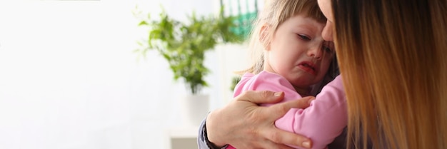 Mãe consola bebê chorando em casa closeup