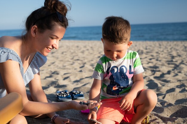 Mãe conversando com o filho na praia.