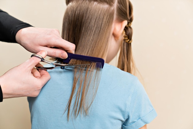 Mãe corta o cabelo molhado da filha cortando o cabelo em casa