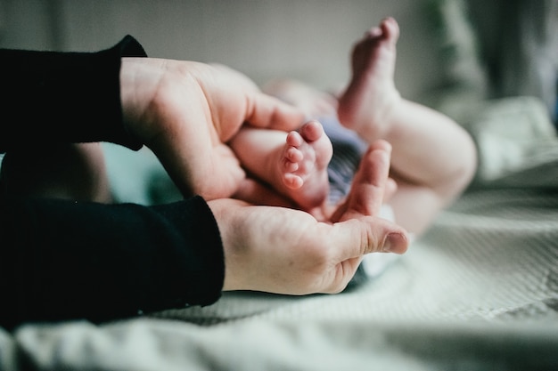 Foto mãe cuidando dos pés do bebê