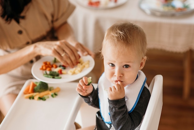 Foto mãe de alto ângulo ajudando o bebê a escolher que comida comer