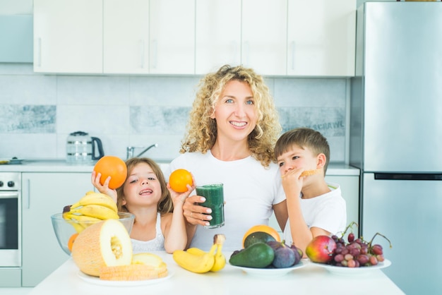 Mãe de família e filha e filho chilenos misturados smoothie verde e laranja com ingredientes de frutas saudáveis Ração de verão