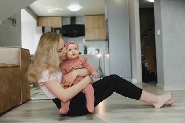 Mãe de família feliz brincando com bebê recém-nascido