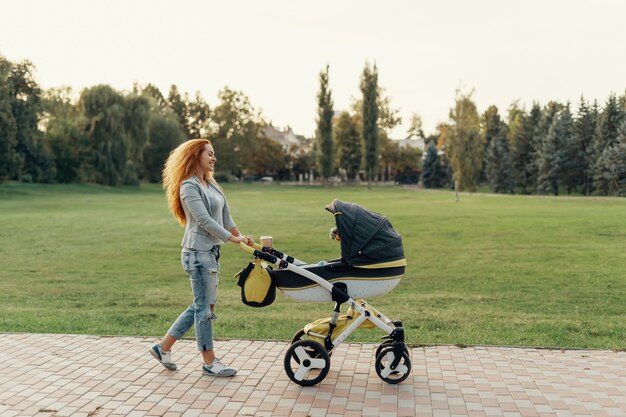 Mãe desfrutando passeio carregando seu filho pequeno em seu bebê troll