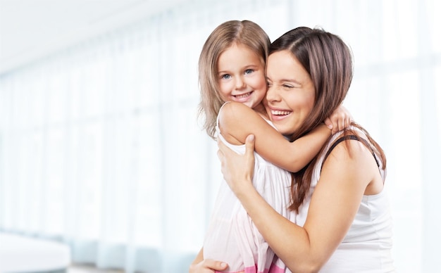 Mãe e bebê beijando e abraçando em casa. Retrato de família sorridente feliz.