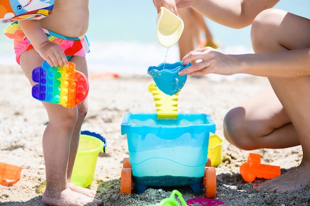 Mãe e bebê brincam na praia do mar