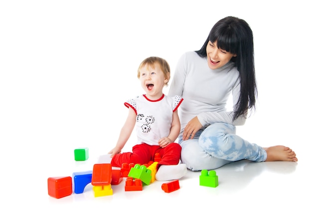 Mãe e bebê brincando com blocos de construção de brinquedo isolado no branco