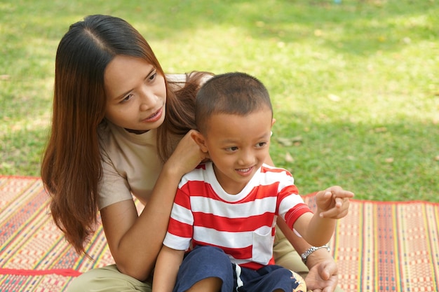 Mãe e bebê brincando no parque alegremente