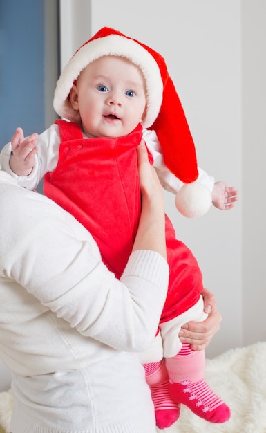 Mãe e bebê com chapéu vermelho de natal