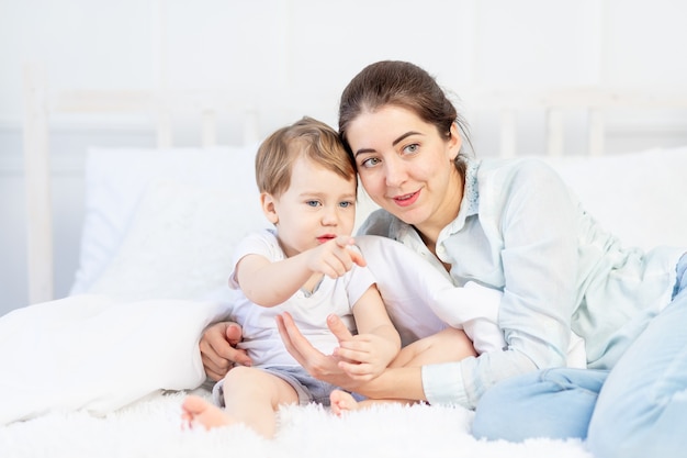 Mãe e bebê conversando em casa na cama, o conceito da relação entre pais e filhos.