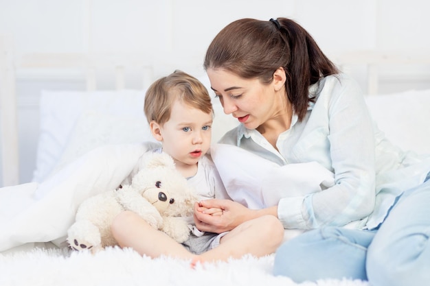 Mãe e bebê conversando em casa na cama o conceito da relação entre pais e filhos
