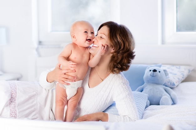 Mãe e bebê em uma cama branca