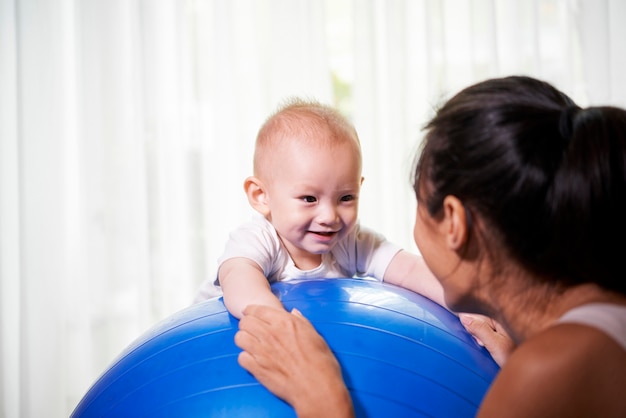 Mãe e bebê exercitando com bola de fitness