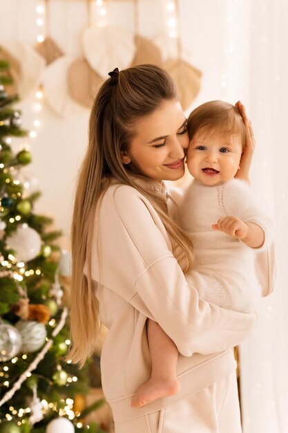 mãe e bebé mãe e bebé contra o fundo da árvore de Natal