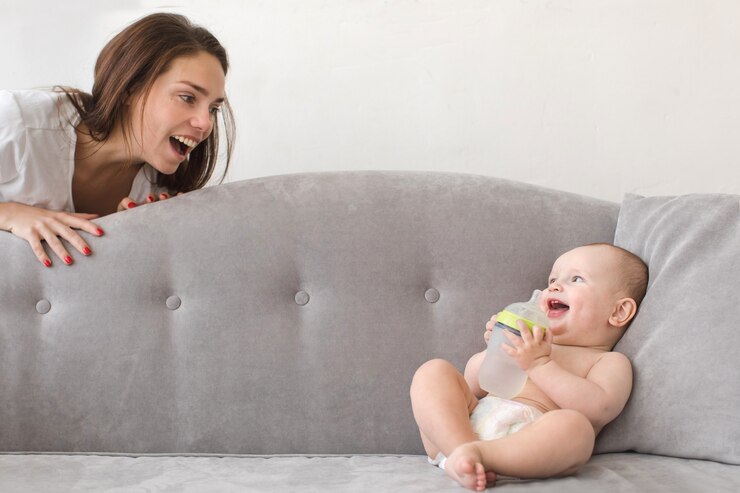 Foto mãe e bebê menino estão jogando no sofá