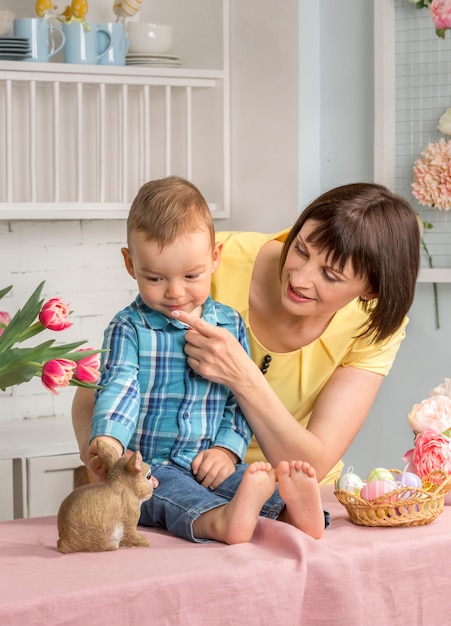 Foto mãe e bebê na páscoa decorada cozinha pastel.