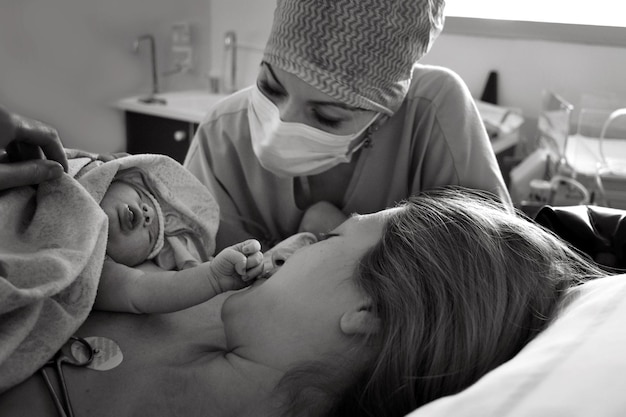 Foto mãe e bebê recém-nascido pele com a pele após o nascimento no hospital