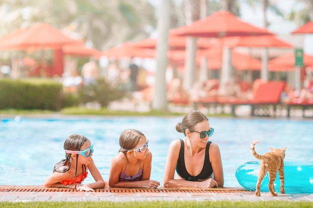 Mãe e dois filhos curtindo férias de verão na piscina de luxo