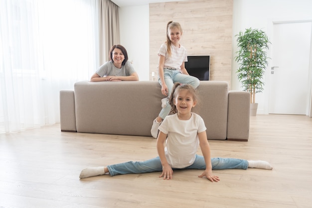 Mãe e duas filhas se divertindo na sala em casa. família feliz e conceito de mãe solteira