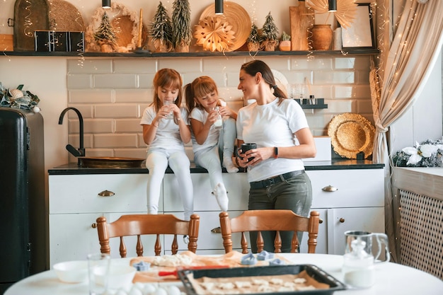 Mãe e duas meninas estão se refrescando na cozinha de férias