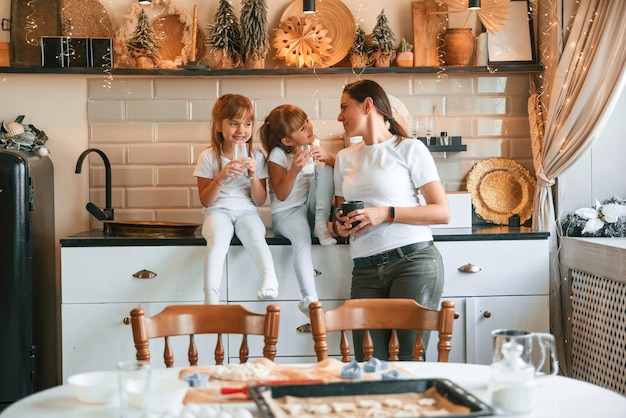 Mãe e duas meninas estão se refrescando na cozinha de férias