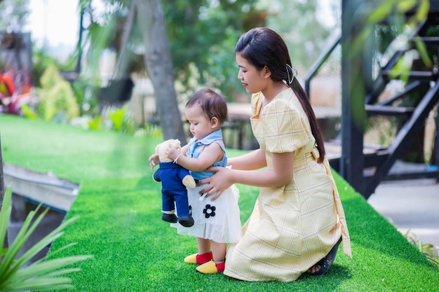 Mãe e filha a brincar na relva.