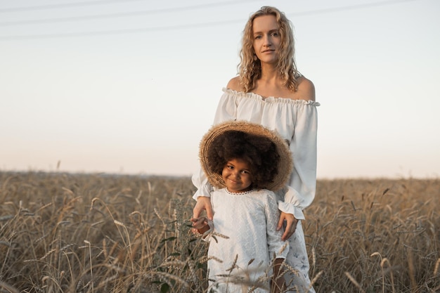 Mãe e filha a caminhar num campo de outono